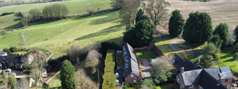 Aerial view of the farm in Derbyshire area with houses and green fields.