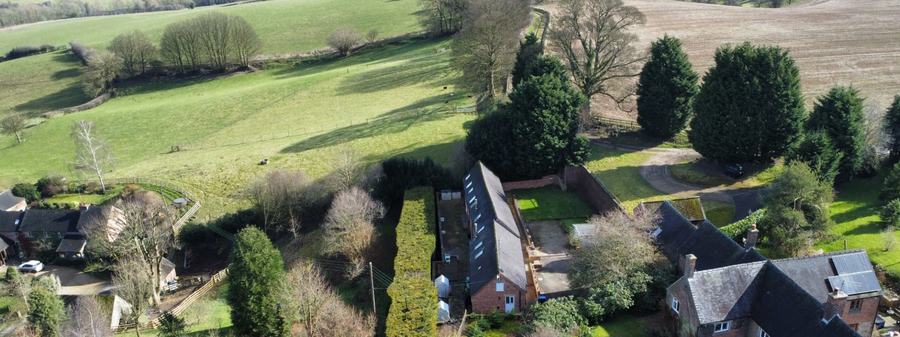 Aerial view of the farm in Derbyshire area with houses and green fields.